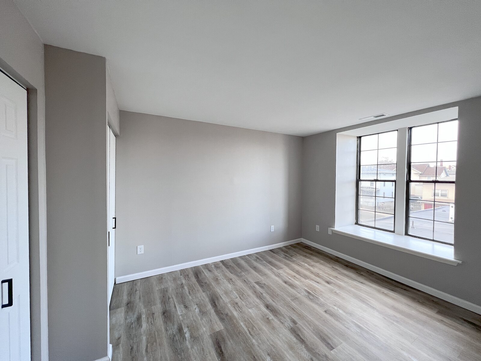 Bedroom with a wall of windows overlooking the neighborhood