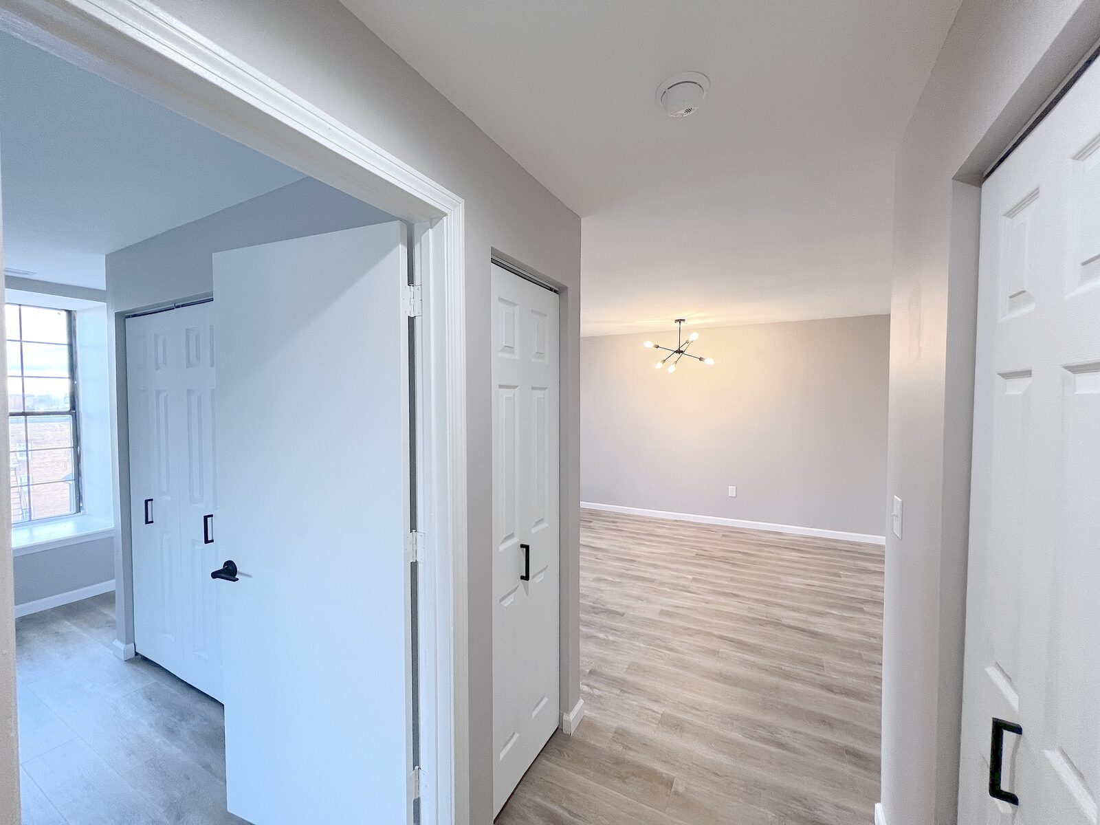 Hallway with double closets leading to a bedroom