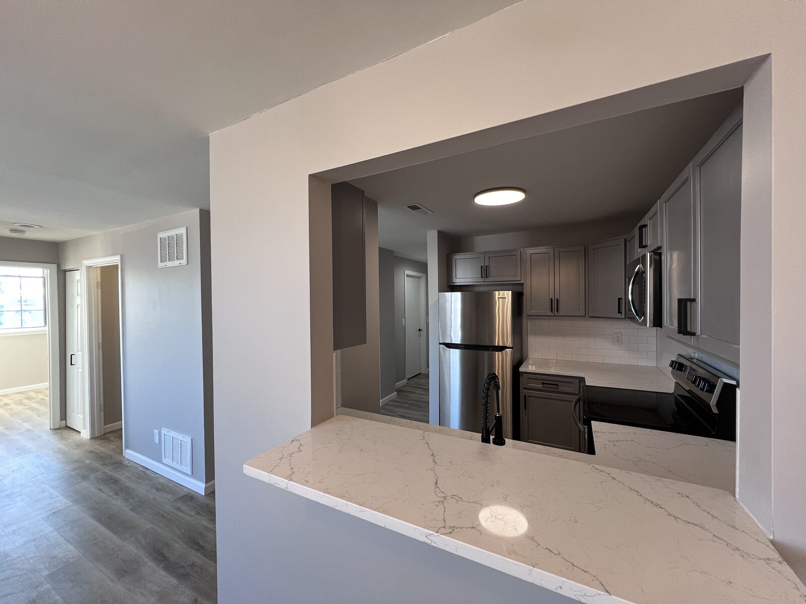 Living room of a Prospect one-bedroom residence with a wall of windows overlooking downtown New Britain